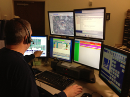 A dispatcher working with many screens at their station